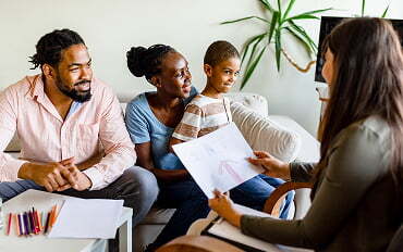 family at home on couch having discussion with ABA provider